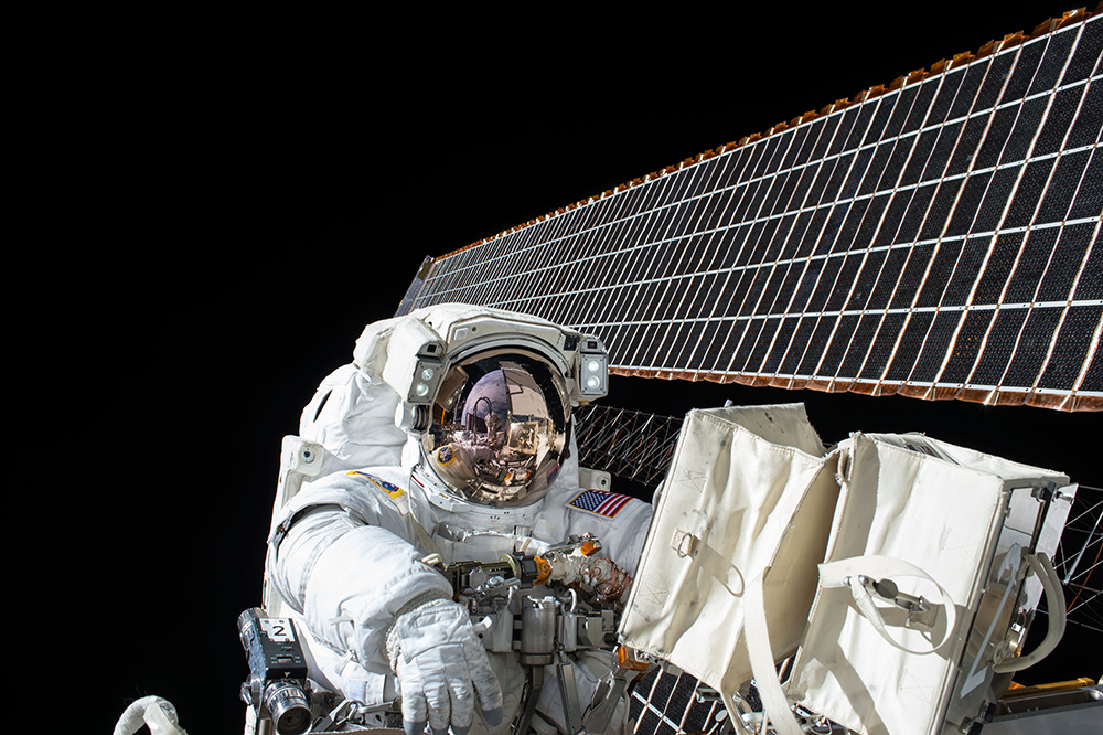 astronaut performing maintenance on space craft while in space