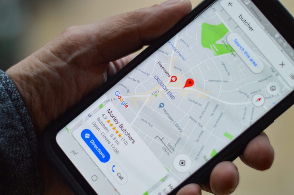 a hand holding a phone displaying a google my business listing